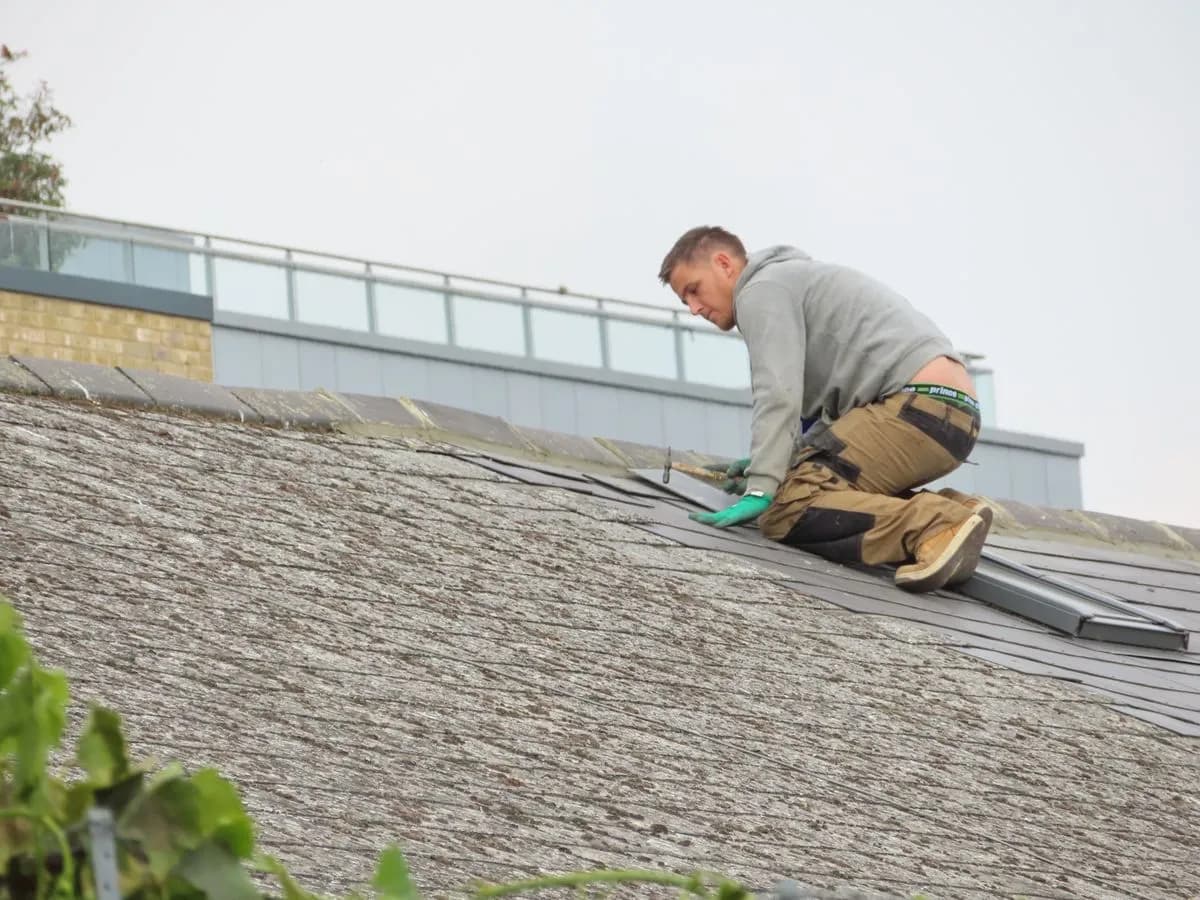 Sample roofing technician inspecting shingles